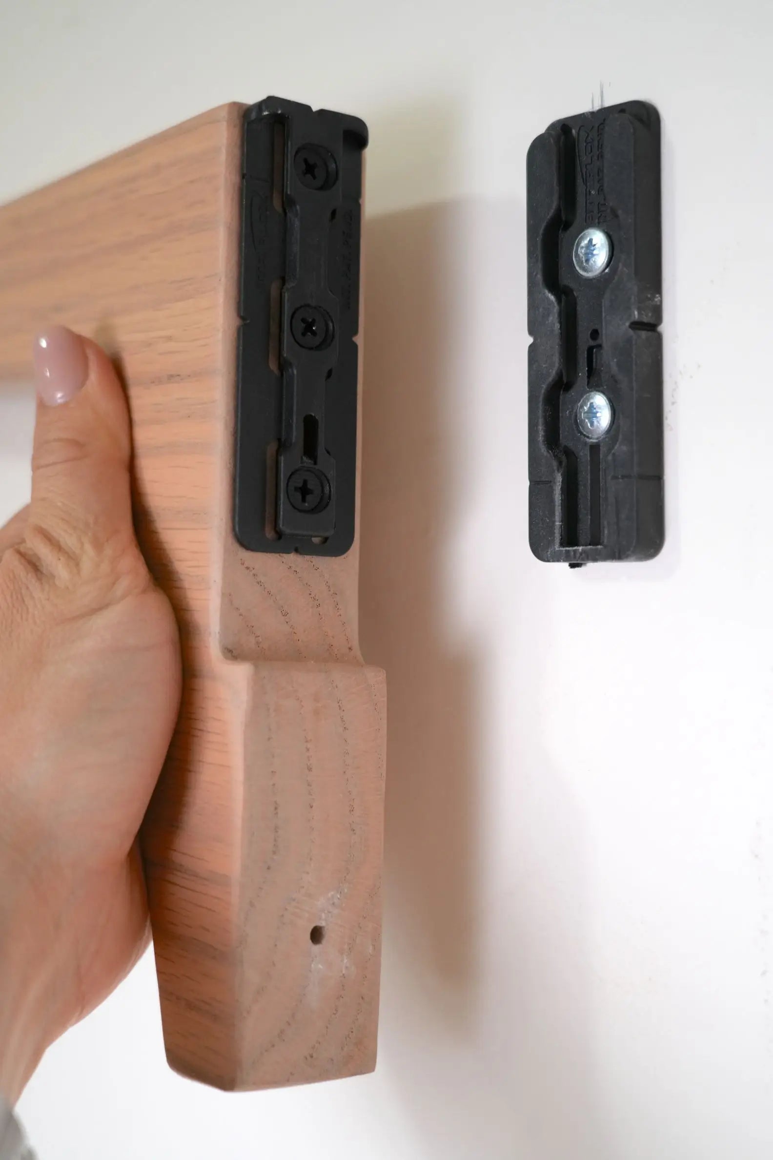 Wooden frame with black wall mount brackets on a white background