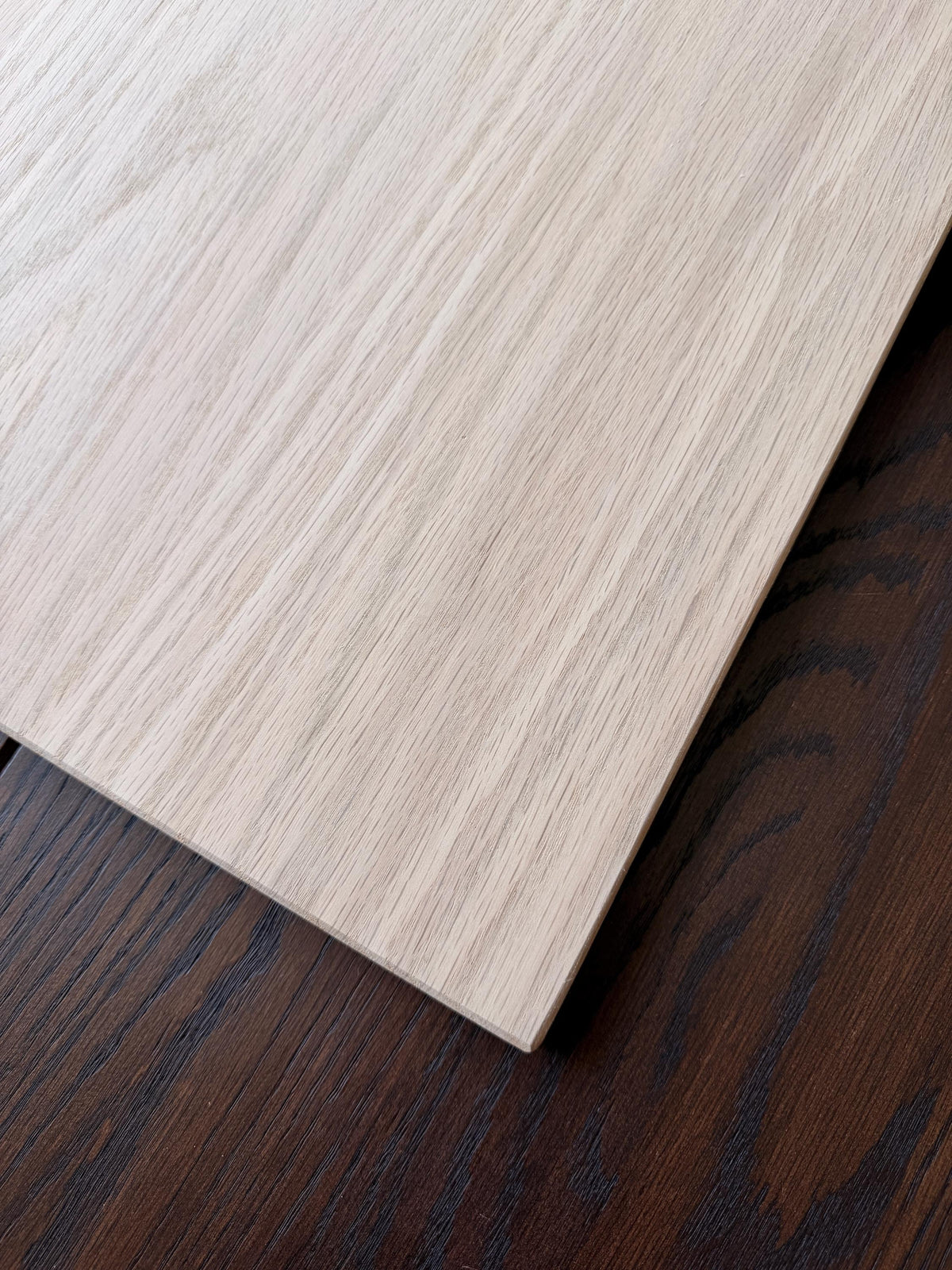 Close-up of the squared corner and sanded face of an unfinished oak shelf board